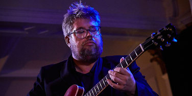 Nick Svarc playing a guitar